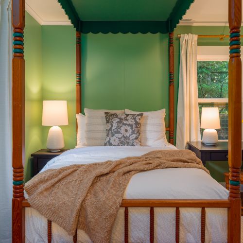 The Scandanavian poster bed was preserved with original green tones and details.  We added a writing desk, large lamps, and linen blackout curtains to make this a fun and contemporary space.