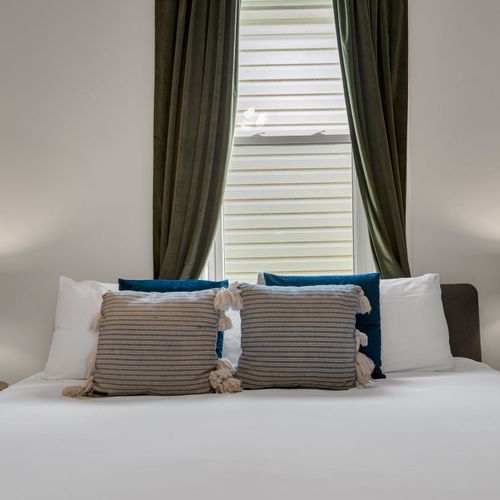 Cozy bed nook w/ teal accents & soft textiles that invite you to curl up.