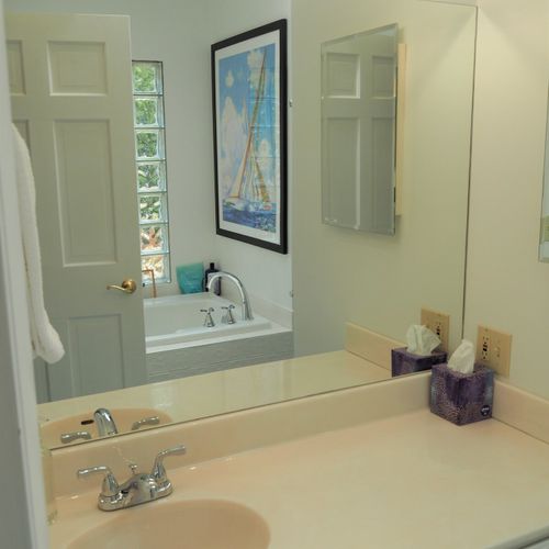 Bathroom #2 (main floor):  this is a private en suite bathroom for the master bedroom (bedroom #1). Features 2 sinks, a large bathtub, and separate shower and toilet facilities.