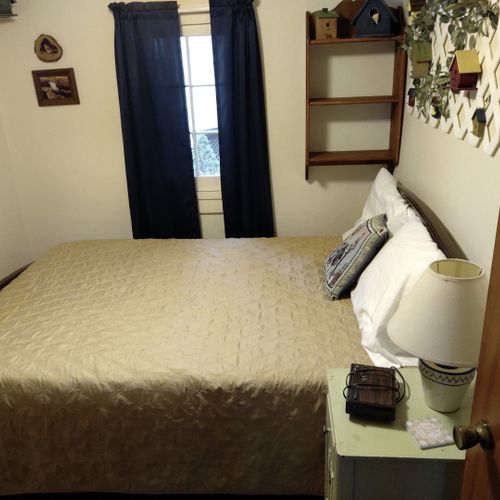 Bedroom #1:  features a full-size bed, nightstand, lamp, and dresser.