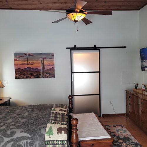 Bedroom #2 (second floor):  very large bedroom features a queen-size bed, walk-out deck, chair, 2 nightstands, 2 lamps, 2 dressers, ceiling fan, television, and private en suite full bathroom