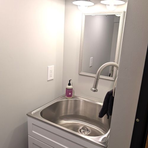 BATHROOM #3 (LOWER LEVEL):  Very convenient half-bath in the basement with a toilet, sink, and mirror.