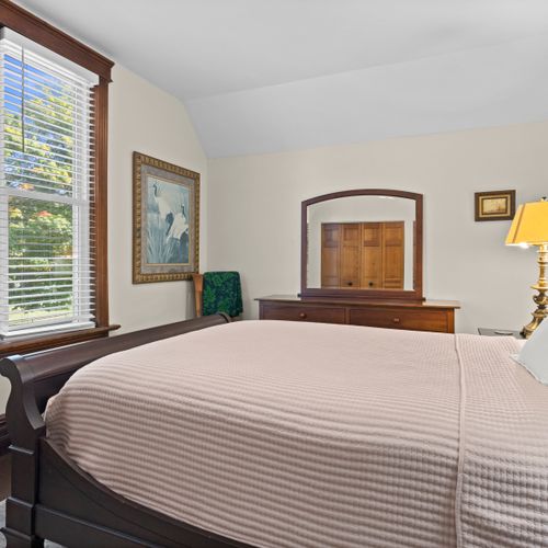 BEDROOM #3 (SECOND FLOOR):  Features a queen-size bed, dresser, large mirror, nightstand, and closet.