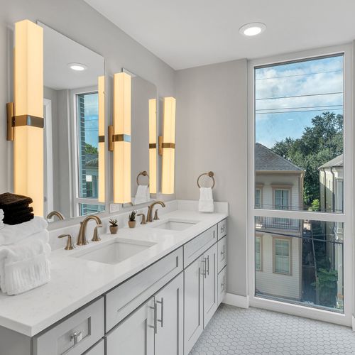 Elegant bathroom featuring dual vanities and a large window for a refreshing morning routine.