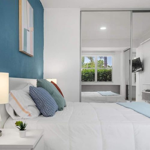 Relax in the cozy embrace of a spacious bedroom graced with a lavish queen-size bed.