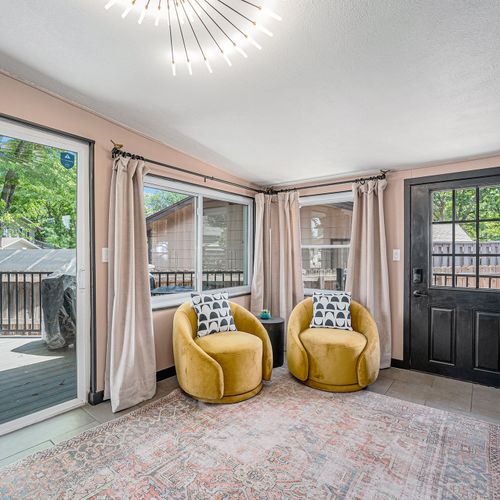 The sunroom invites relaxation with its two cozy chairs, offering a serene spot to enjoy natural light and peaceful moments.