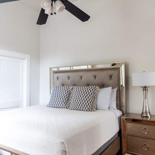 Sink into comfort in this stylish bedroom featuring a plush bed with a mirrored headboard and tasteful decor. Perfect for a restful night's sleep, this room combines luxury and relaxation for an unforgettable stay.