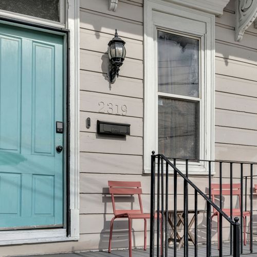 Welcoming teal front door w/ a classic exterior — a charming first impression.