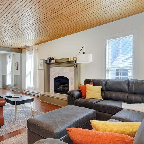 - cozy living area with plush leather sectional, colorful pillows, and wood paneled ceiling
- elegant fireplace and large windows create a warm, light filled retreat
- perfect for relaxing with a good book or gathering for movie nights
