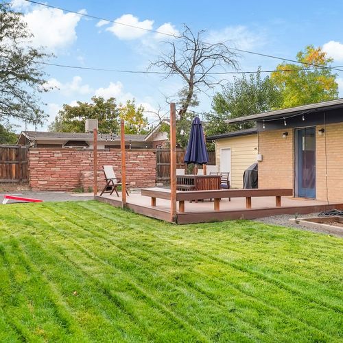 - large backyard with a beautiful green lawn, string lights, and spacious raised deck
- ideal for tossing a frisbee, playing yard games, or just lounging in the sun
- peaceful outdoor haven that invites relaxation and connection