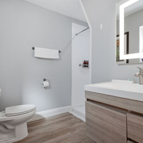Sleek vanity w/ bright lighting & plenty of counter space to get ready.