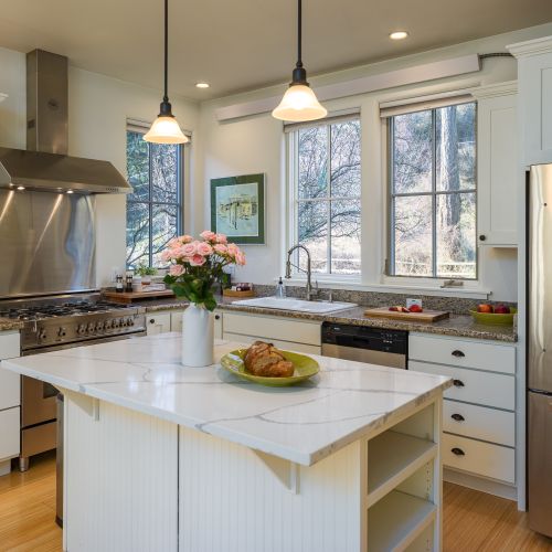 A fully equipped, sun-filled kitchen with modern appliances, generous counter space, and a welcoming island for gathering.