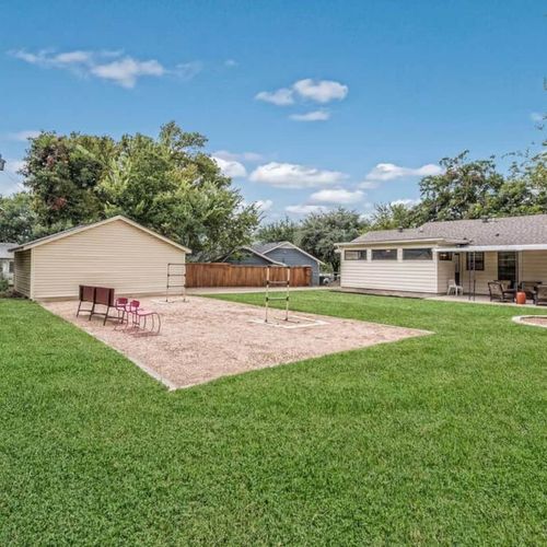 Fun, fenced backyard with ladder ball, fire pit, hammock and parking at the garage behind a locked gate.