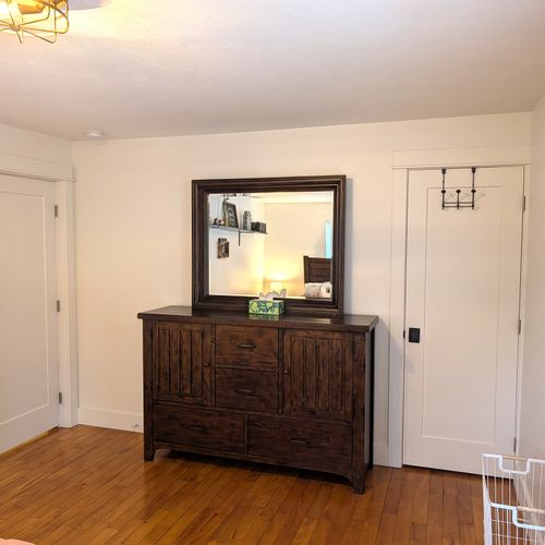 BEDROOM #1 (MAIN FLOOR):  Gorgeous main floor bedroom with a queen-size bed, nightstands, lamps, ceiling fan, dresser, mirror, and closet.