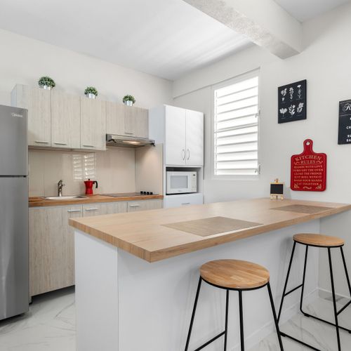 Gorgeous wood counter and modern stools. Eat−in kitchen.