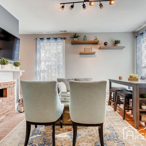 - fireplace front lounge with soft armchairs, plush sofa, and a tv above the mantel
- dual windows and elevated dining table give the room balance and function
- modern lighting and clean lines offer both comfort and visual appeal