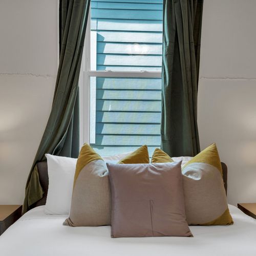 Dreamy window seat bathed in soft natural light w/ lush curtains framing the view.