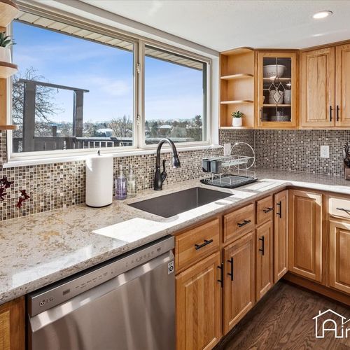 - granite counters and a deep under mount sink make cleanup simple and stylish
- mosaic backsplash shimmers under sunlight pouring through the wide kitchen window
- open shelving and glass cabinets offer practical and attractive kitchen storage