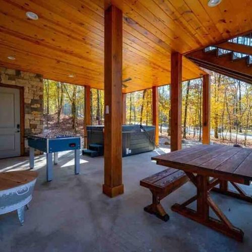 The hot tub, dining table & foosball on the bottom floor of the the outdoor area.
