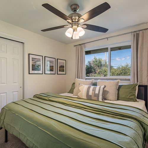 Wake up to natural sunlight streaming through large windows in this welcoming second upstairs bedroom.