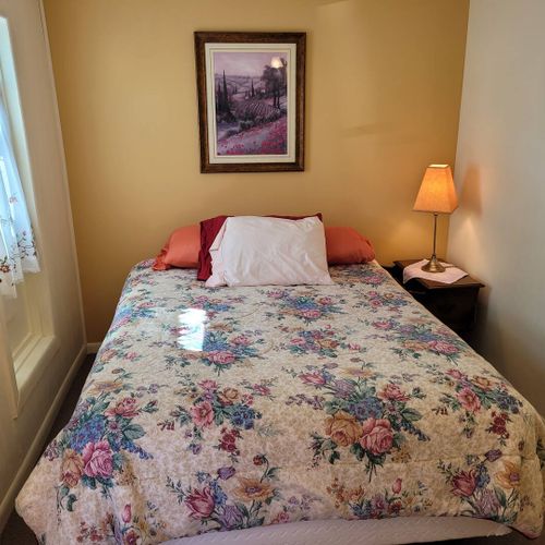 BEDROOM #1:  Features a queen-size bed, dresser, closet, and chair.