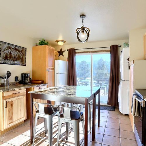 - cook in a charming rustic kitchen with granite counters and wood cabinetry
- enjoy cozy meals at the high top table with seating for four under antler lighting
- step through the sliding doors to soak in peaceful pine and mountain scenery