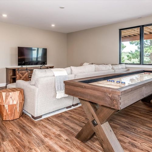 - kick back in the cozy lower level lounge with a large sectional and shuffleboard game
- watch movies, play a match, or enjoy time together in this laid back family space
- wood flooring and natural light add warmth to the game ready vibe