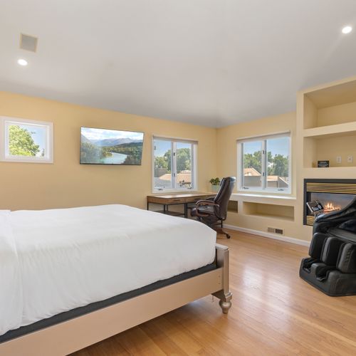 Bright, charming bedroom with plush king bed, workspace and massage chair for convenience.