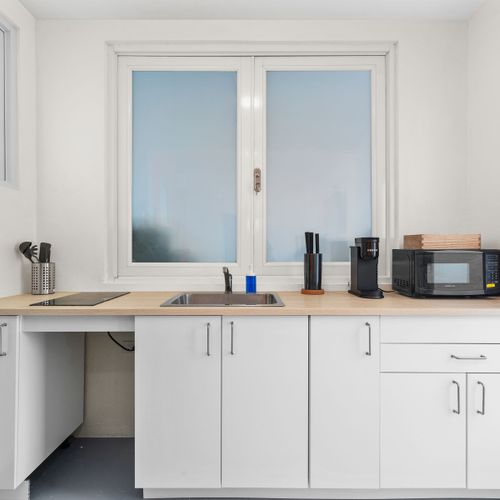 Practical kitchen setup including key appliances: refrigerator, sink, and microwave.