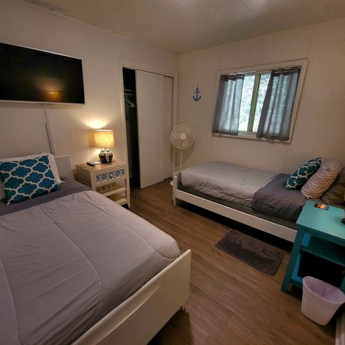 Bedroom #3:  bedroom #3 features two twin-size beds, a closet, and nightstands with lamps.