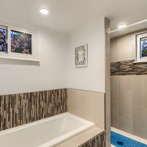 A separate stand-in master shower sits adjacent with floor to ceiling tile and faux stained-glass windows for added privacy.