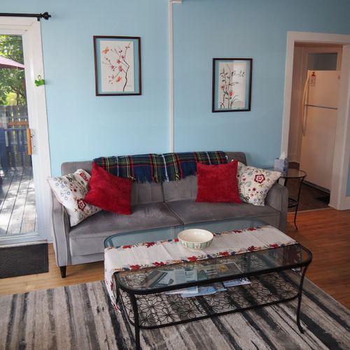 Living room:  comfy and cozy living room with sofa, comfy chair, futon, 2 coffee tables, and a large live streaming television that uses the cottage's high-speed cable wi-fi.