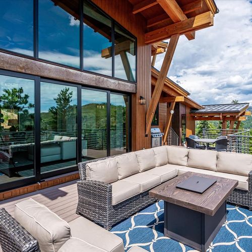 - lounge on the oversized sectional while mountain views reflect off tall glass panels
- cozy fire table invites evening conversations beneath the timber framed roof
- this inviting outdoor space blends style with panoramic serenity