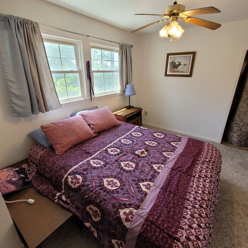 Bedroom #1 ( second floor):  large master bedroom with a queen-size bed, closet, vanity, ceiling fan, pedestal fan, and nightstand.
