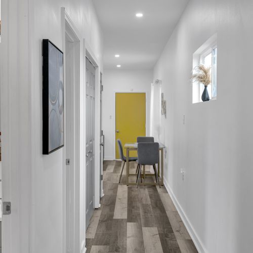 Bright, inviting hallway leading to thoughtfully designed spaces. Modern accents and ample natural light make it the perfect retreat.