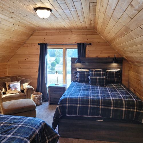 BEDROOM #3 (SECOND FLOOR BUNK ROOM ABOVE GARAGE):  Features 2 queen-size beds, a comfy chair, wall A/C unit, wall heater, electric fireplace, 2 nightstands, a dresser, mini refrigerator, and live streaming television (via Sling).