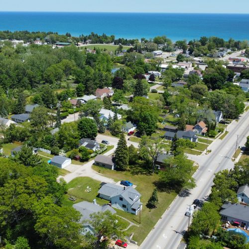 Exterior:  looking northeast with the house in the foreground and downtown oscoda and lake huron in the background.