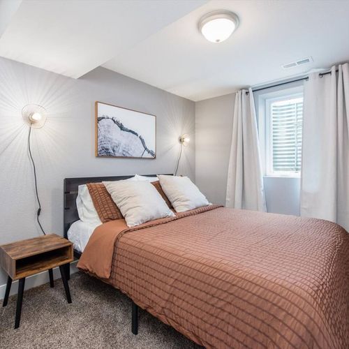 A tastefully decorated room is fitted with a queen-sized bed and matching nightstands completes the lower floor.