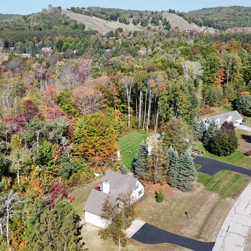 OVERVIEW:   Aerial view with the house in the foreground and the ski slopes of Crystal Mountain in the background