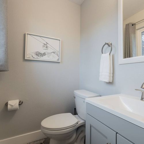- freshen up in a spotless half bath with bright lighting and modern fixtures
- soft neutral tones and a minimalist aesthetic make this space feel calm and clean
- framed mountain artwork adds a subtle outdoorsy charm to the decor