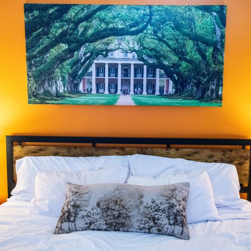 Drift off under soft lighting in this cozy, warmly decorated bedroom.