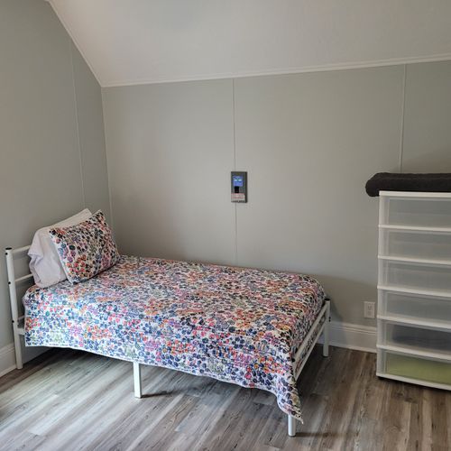 Bedroom #4 (second floor):  features a queen-size bed, twin bed, window a/c unit, ceiling fan, nightstand, lamp, dresser, and a closet.