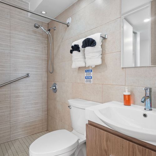 Refresh and rejuvenate in our clean, well-lit bathroom outfitted with plush towels, an easily accessible shower, and all the essentials for a comfortable stay.
