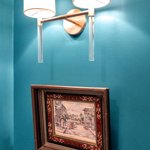 Rich teal accent wall w/ framed artwork that makes the room feel curated & bold.