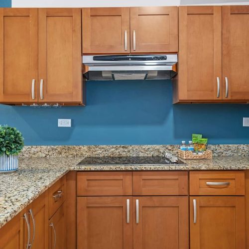 It features a wooden cabinet, microwave and a toaster oven.