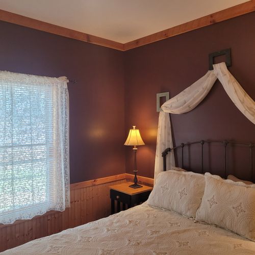 Bedroom #1 (main floor):  features a queen-size bed, dresser, mirror, nightstands, and lamps.