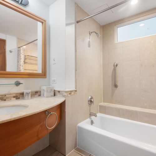 Relax and rejuvenate in our clean, contemporary bathroom featuring a full tub and shower