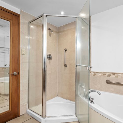 Spacious and functional bathroom offering a large mirror, ample counter space, and modern fixtures.