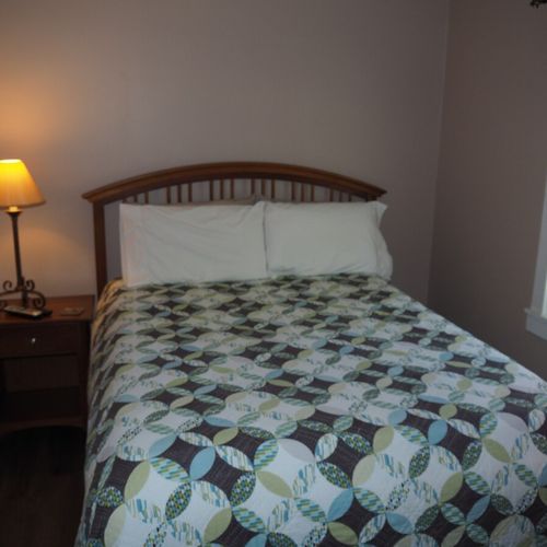 Bedroom #1:  features a queen-size bed, nightstand, lamp, dresser, mirror, closet, and television.