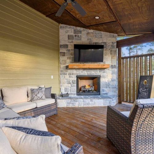 An outdoor fireplace surrounded by an oversized sectional on the covered patio!